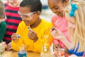 Students doing a science experiment with food coloring dyes.