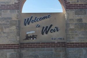 A sign reading "Welcome to Weir Est. 1903" in Weir, Texas.