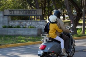 Two passengers ride a moped in Rollingwood, Texas.