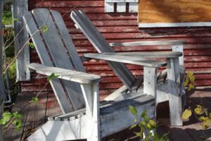 Two wooden chairs on a porch.
